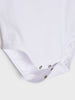 Close-up of a white shirt with button details on a light gray background