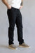 Person wearing black pants and beige shoes on a plain background