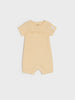 Beige baby romper with text on a white background
