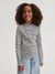 Child wearing a striped long-sleeve shirt and light blue jeans on a white background