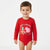 A young child wearing a red long-sleeve bodysuit with a 'Merry Christmas' Peppa Pig graphic on the front, standing against a plain white background.