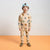 A young boy stands facing forward wearing a beige two-piece pajama set with a colorful dinosaur print, a light blue baseball cap, and brown shoes, set against a split white and orange studio background.