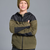 A child wearing a zip-front fleece jacket with olive green and black color blocking, paired with a matching olive green beanie, against a solid gray studio background.