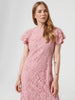 Woman wearing a pink lace dress on a white background