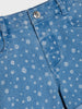 Close-up of blue denim fabric with white floral pattern
