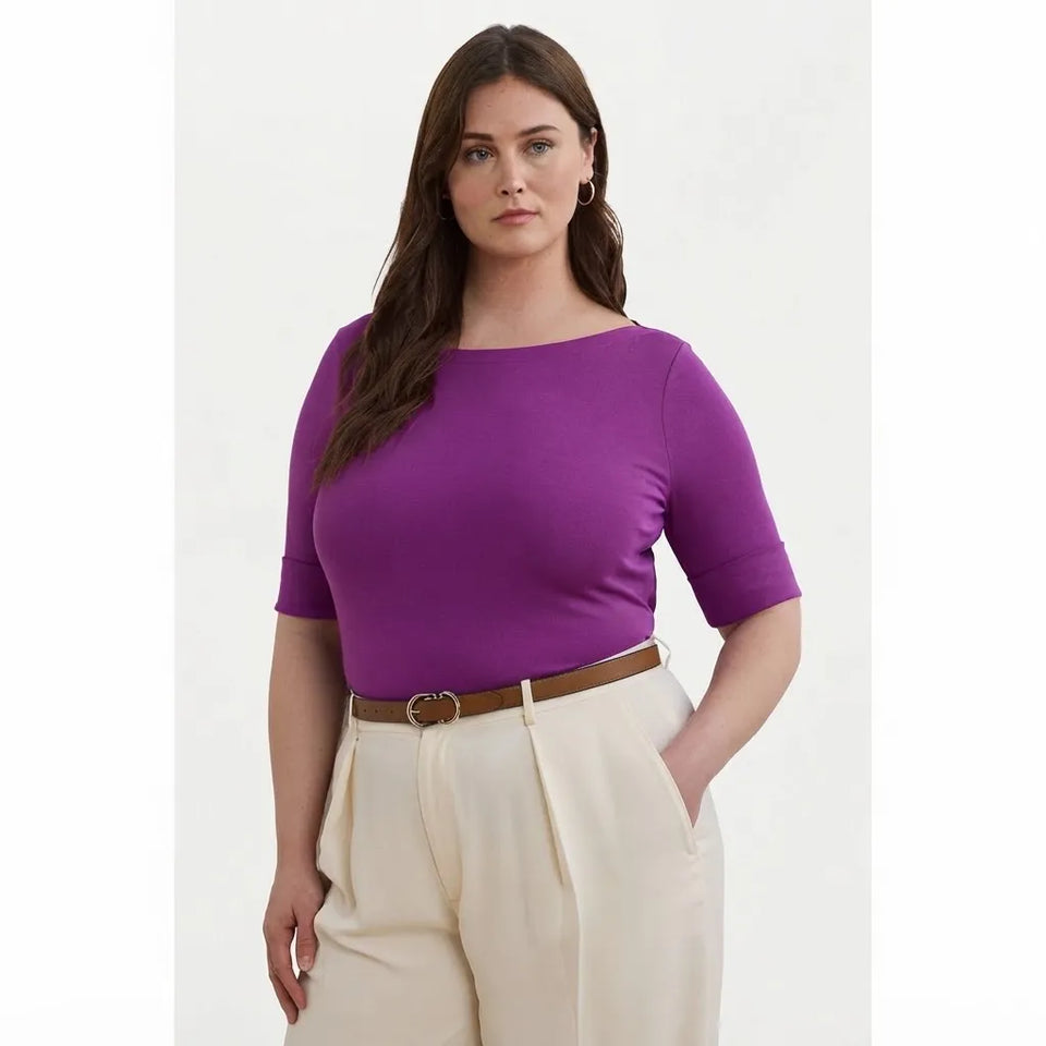 A woman modeling a purple short-sleeve boat-neck top paired with cream-colored trousers and a brown belt, set against a plain light background.