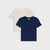 Two short-sleeve kids' t-shirts by Maison de Pierre, displayed as a flat lay. The front shirt is solid navy blue, and the back shirt is cream with a small blue floral pattern.