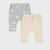 Two pairs of baby pants, one with cloud pattern and the other with stripes, on a light gray background.