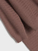 Close-up of a brown textured sweater on a light gray background