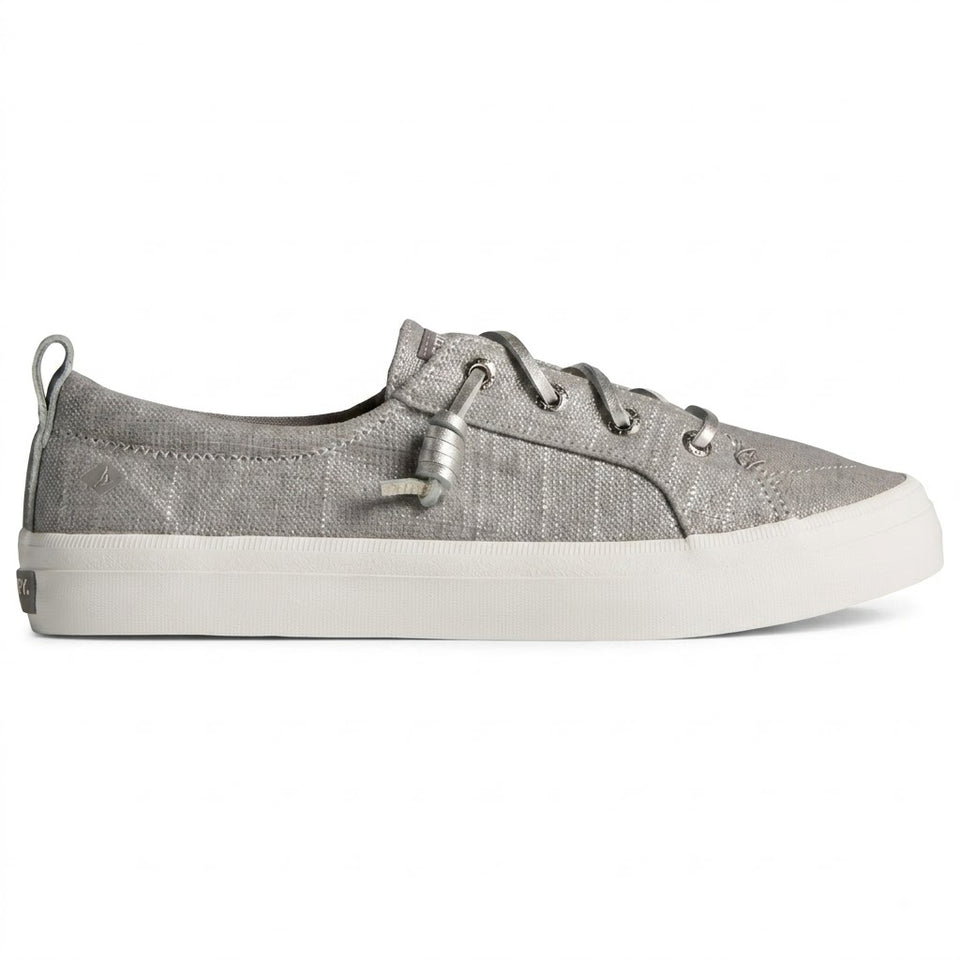 A low-top canvas sneaker in metallic silver with matching silver laces and a thick white rubber sole, shown from a side profile on a white background.