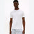 A man wearing a plain white short-sleeve crewneck t-shirt and white shorts with small black polka dots, standing against a plain white studio background.