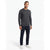 A man modeling a dark gray long-sleeve crewneck sweater, paired with dark navy blue jeans and white sneakers, against a plain white studio background.