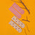 Two pairs of fuzzy ankle socks arranged on a bright yellow background with small brown twigs. One pair is solid dusty pink, and the other pair is cream with a small multicolor floral and leaf pattern.