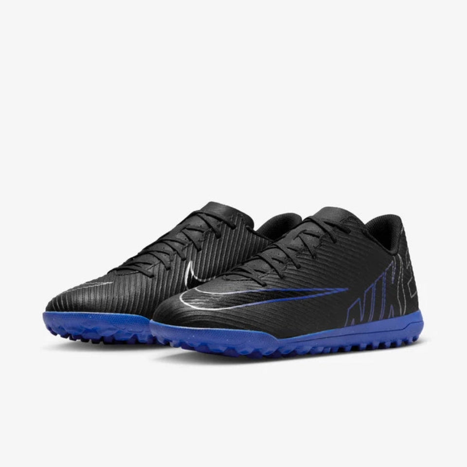A pair of Nike soccer cleats in black with a vibrant blue sole and a subtle blue Swoosh logo, displayed on a clean light gray background.