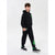 A child wearing a black zip-up hoodie and matching sweatpants with green graphic accents, standing against a light gray studio background.