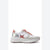 A white and silver sneaker with coral pink accents, including the laces, heel tab, and star-shaped side detail, shown in a side profile on a white background.