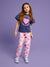 Young girl wearing a navy t-shirt with a pink heart design and white pants with pink heart patterns on a purple background
