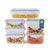 Six clear plastic storage containers with blue-lidded seals, shown filled with snacks and food items on a white background. A circular badge on one container reads 'Lifetime Warranty.