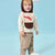 A toddler wearing a beige and brown hooded sweatshirt with a red accent graphic, paired with beige pants, standing against a light blue studio background.