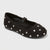 Black loafer shoe with a gold buckle on a white background