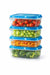 Set of four stacked food storage containers with blue lids containing different vegetables on a white background