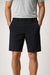 Person wearing black shorts and a gray shirt on a white background
