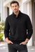 Man wearing a black cable knit sweater with a blurred background