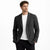 Man wearing a gray blazer over a white shirt on a white background