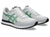 White and green sneakers with black soles on a white background