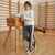 A boy wearing a light gray sweatshirt with a 'Cahiers' logo and dark gray track pants with a white side stripe, leaning on a wooden gymnastics vault table in a gym.