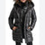 A woman wearing a shiny black hooded puffer jacket with horizontal quilting, shown from the shoulders down against a plain white background.