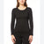 A woman wearing a black long-sleeve ribbed knit top and matching black leggings, shown from the nose down against a plain white studio background.