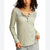 A woman wearing a ribbed long-sleeve henley top in a light sage green color, featuring a lace yoke detail across the chest with dark buttons.