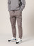 Person wearing a gray hoodie and pants with white sneakers on a light background