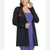 Woman wearing a black cardigan over a purple outfit on a white background