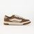Brown and beige sneaker with white laces on a light gray background