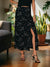 Person wearing a black sequin skirt in a home setting with plants and furniture.