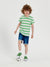 Child wearing a green and white striped shirt with blue shorts on a white background