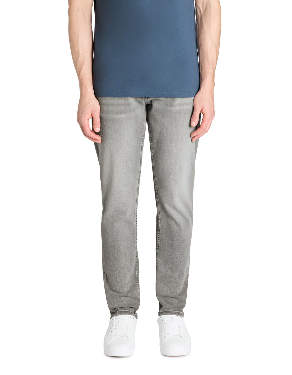 Person wearing gray pants and a blue top on a white background