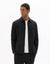 Man wearing a black jacket over a white shirt on a white background