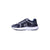 A navy blue athletic sneaker with a white midsole and a white stylized chevron logo on the side, shown from a profile view against a plain white background.
