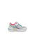 A toddler's athletic sneaker in white and silver glitter, featuring a pink collar lining, turquoise and pink laces, and a white hook-and-loop strap across the top. The shoe is shown from a side profile view against a plain white background.