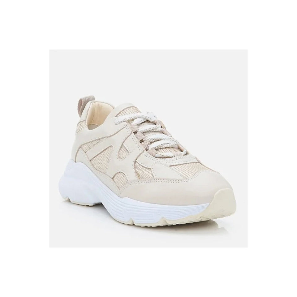 A single chunky sneaker in a light beige and off-white colorway, shown from a three-quarters angle against a clean, light gray studio background.