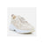 A single chunky sneaker in a light beige and off-white colorway, shown from a three-quarters angle against a clean, light gray studio background.