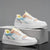 A pair of low-top platform sneakers in white with pastel accents in light blue, peach, yellow, and lavender, displayed on a gray box against a gray background.