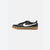 A Nike low-top sneaker in black suede and leather with a white Swoosh and a gum rubber sole, shown from the side on a light gray background.