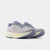 A pair of New Balance running shoes in light lavender and cream, shown from a side profile view against a light gray background.