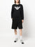 Person wearing a black outfit with a logo on a white background