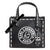 A black leather Karl Lagerfeld Paris handbag with white contrast stitching, a large white circular logo patch on the front, and a hanging Karl Lagerfeld character charm, shown on a plain white background.