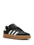 Black Adidas sneaker with white stripes on a white background